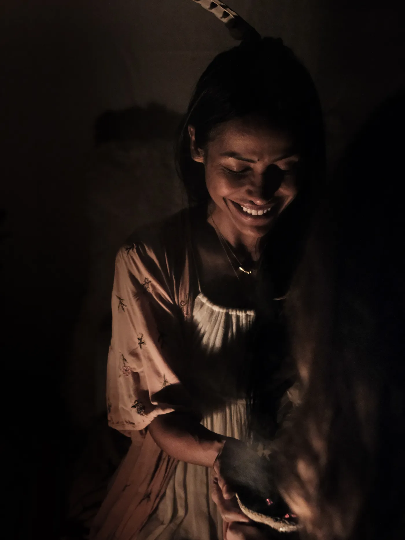 Tatiana smiling by firelight